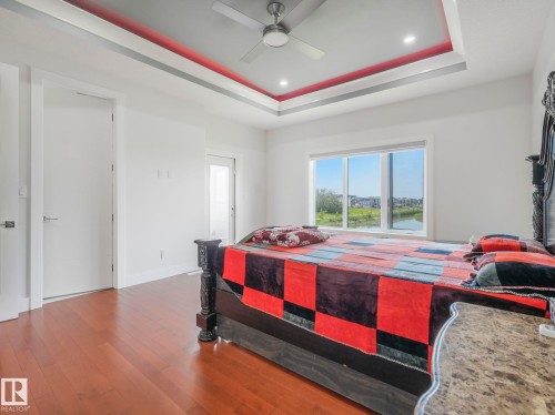 Recessed lighting, ceiling fan, tray ceiling, wood-finish flooring, and a large window - 120 38 Street Sw, Edmonton, AB 