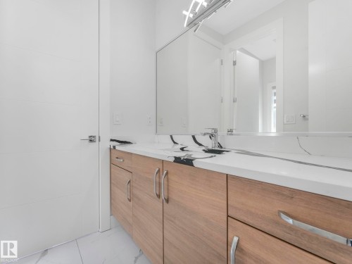 Wood-finish vanity with ample storage, integrated sink, and sleek countertop - 120 38 Street Sw, Edmonton, AB 