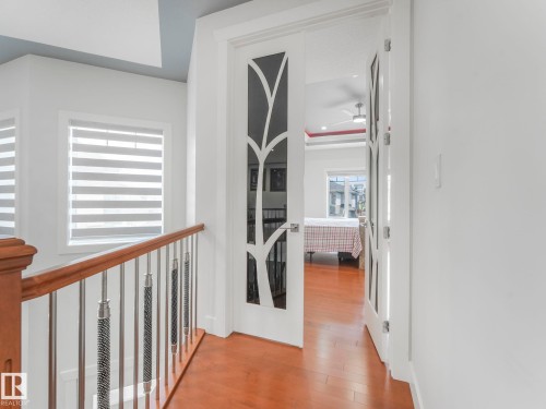 Hardwood-finish flooring, white walls, and a modern stair railing with polished chrome balusters - 120 38 Street Sw, Edmonton, AB 