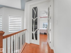 Hardwood-finish flooring, white walls, and a modern stair railing with polished chrome balusters - 