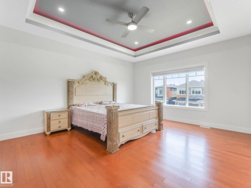 Hardwood-style flooring throughout, tray ceiling with recessed lighting and a ceiling fan, and large window - 120 38 Street Sw, Edmonton, AB 
