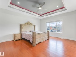 Hardwood-style flooring throughout, tray ceiling with recessed lighting and a ceiling fan, and large window - 