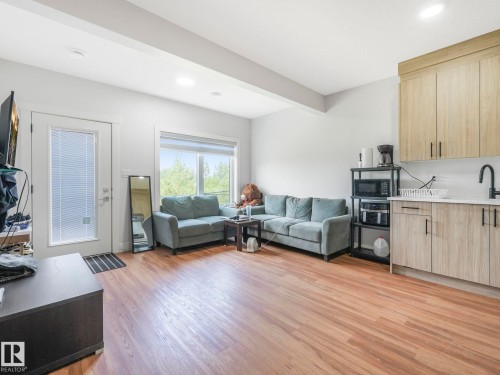 Wood-finish flooring, recessed lighting, expansive window, light wood-finish cabinetry, and white countertops - 120 38 Street Sw, Edmonton, AB 