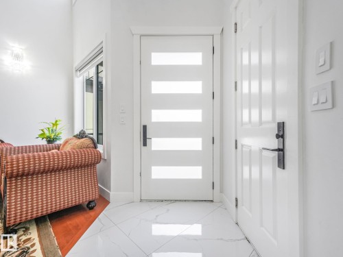 White modern door with frosted glass panels and black hardware - 120 38 Street Sw, Edmonton, AB 