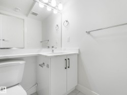 White vanity with a rectangular undermount sink, a chrome faucet, and a large wall-mounted mirror - 