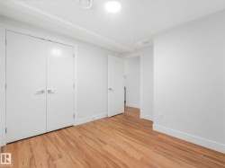 Wood-finish flooring, white walls, and a ceiling-mounted light fixture - 