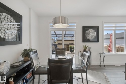 White walls, a glass door leading to a deck, and window coverings - 153 Cavanagh Common Sw, Edmonton, AB 
