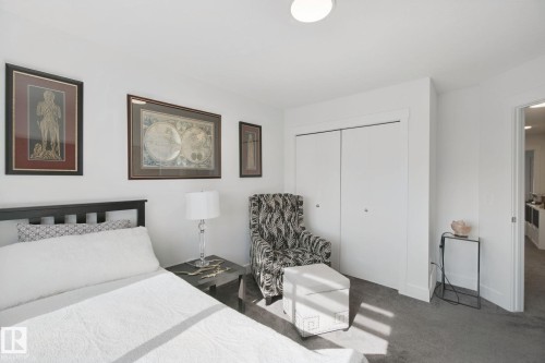 White walls, gray carpet, and a built-in closet with bi-fold doors - 153 Cavanagh Common Sw, Edmonton, AB 