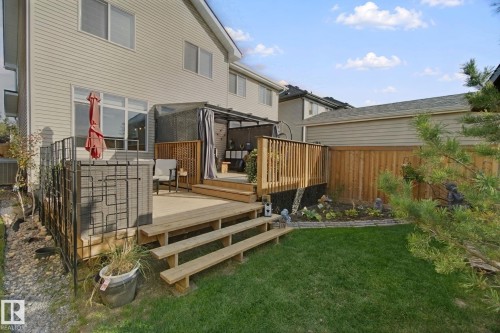 Multi-level wood deck with steps, a privacy screen, and a covered area - 153 Cavanagh Common Sw, Edmonton, AB 