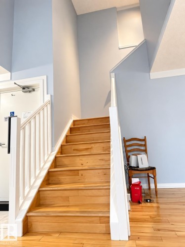 Wood-finish staircase with white balusters and handrail - 18929 99A Avenue Nw, Edmonton, AB 