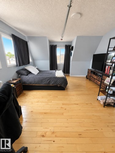 Light wood-finish flooring, multiple windows, and sloped ceiling details - 18929 99A Avenue Nw, Edmonton, AB 