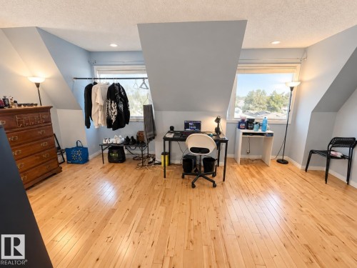Room featuring wood-finish flooring, recessed lighting, and sloped ceilings with integrated windows - 18929 99A Avenue Nw, Edmonton, AB 