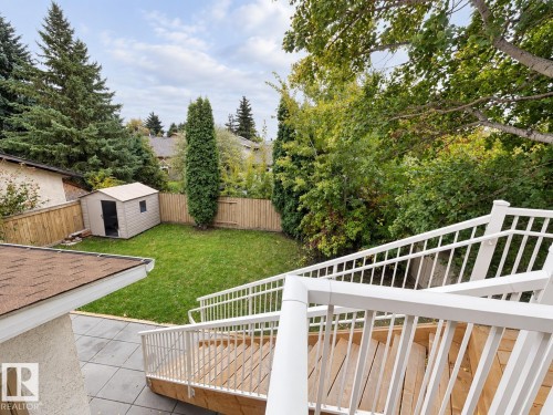 Expansive backyard featuring a manicured lawn, wood fencing, and mature trees - 18929 99A Avenue Nw, Edmonton, AB 