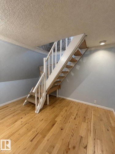 Wood-finish flooring, white wood railings, recessed lighting, light blue wall paint, and white trim - 18929 99A Avenue Nw, Edmonton, AB 