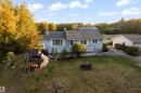 Light blue siding exterior with white trim, a dark shingled roof, and an elevated deck with white railings - 52314 Rge Road 215, Rural Strathcona County, AB 