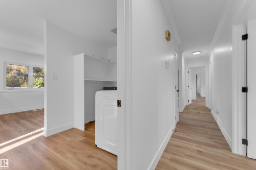 Wood-finish flooring throughout, bright white walls, crown molding, built-in shelving, and a prominent window - 52314 Rge Road 215, Rural Strathcona County, AB 