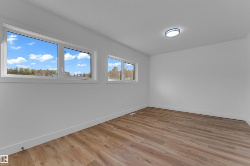 Wood-finish flooring, white walls, multiple windows, and a flush-mount ceiling light - 52314 Rge Road 215, Rural Strathcona County, AB 