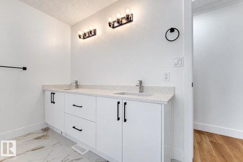 Dual vanity with white cabinetry, matte black hardware, and an integrated countertop - 52314 Rge Road 215, Rural Strathcona County, AB 