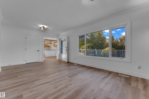 Wood-finish flooring, white trim, recessed lighting, and a large picture window overlooking a balcony - 52314 Rge Road 215, Rural Strathcona County, AB 