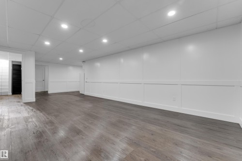 Spacious room featuring wood-finish flooring, recessed lighting, and white paneled walls - 52314 Rge Road 215, Rural Strathcona County, AB 