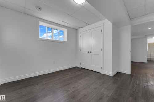 Dark wood-finish flooring, white walls, and a drop ceiling - 52314 Rge Road 215, Rural Strathcona County, AB 