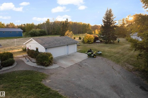 Detached garage with dual overhead doors, extensive asphalt driveway, and mature landscaping - 52314 Rge Road 215, Rural Strathcona County, AB 