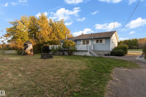 Blue siding, white porch railing, front porch, shingled roof, gravel driveway - 52314 Rge Road 215, Rural Strathcona County, AB 