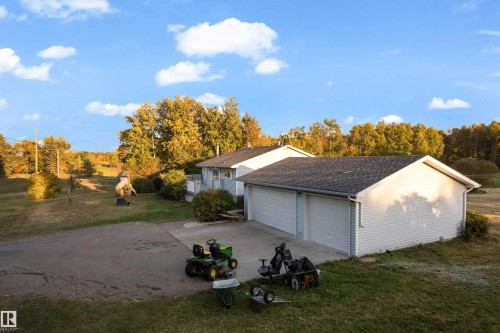 Detached two-car garage with white vinyl siding, asphalt shingle roofing, and light blue garage doors - 52314 Rge Road 215, Rural Strathcona County, AB 
