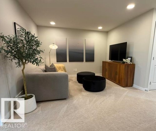 Recessed lighting, wood-finish media console, neutral-toned walls, and carpet flooring - 16 Clichy Close, St. Albert, AB 