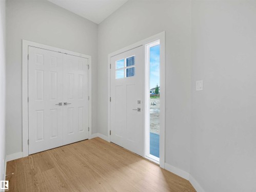 Entryway with wood-finish flooring, white walls, and a vaulted ceiling - 22 Dalquist Bay, Leduc, AB 