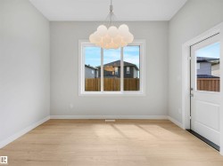 Light wood-finish flooring, white walls, and a contemporary chandelier - 
