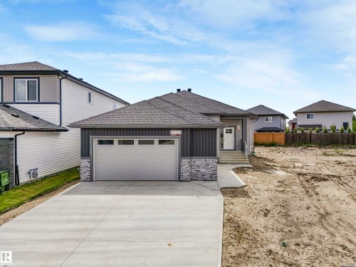 Contemporary exterior featuring vertical siding and stone accents - 22 Dalquist Bay, Leduc, AB 