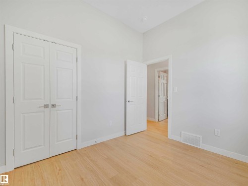 Wood-finish flooring, white walls, and a white paneled door - 22 Dalquist Bay, Leduc, AB 