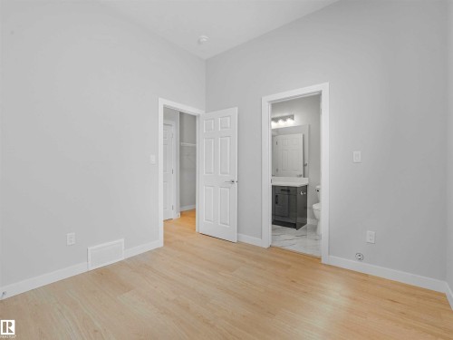 Light wood-finish flooring, white trim, and a gray vanity with a single basin sink - 22 Dalquist Bay, Leduc, AB 