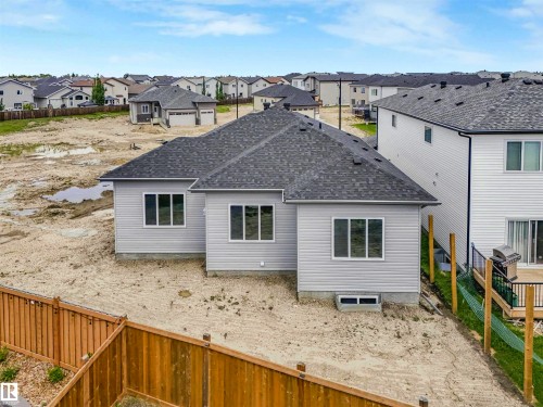 Light gray siding exterior with multiple windows and a shingled roof - 22 Dalquist Bay, Leduc, AB 