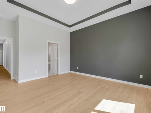 Recessed ceiling detail, light wood-finish flooring, white baseboards, and a neutral color palette - 22 Dalquist Bay, Leduc, AB 