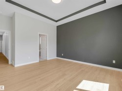 Recessed ceiling detail, light wood-finish flooring, white baseboards, and a neutral color palette - 