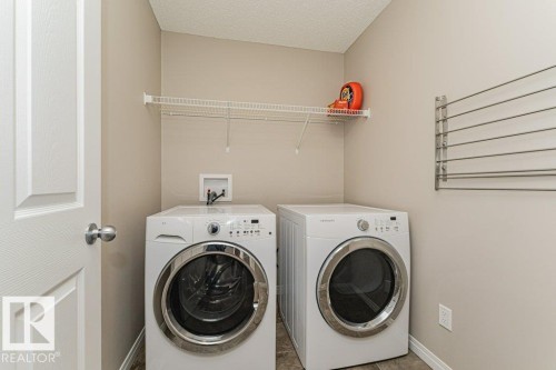 Laundry area featuring a wire shelf, tiled flooring, and a wall-mounted drying rack - 3203 Carpenter Landing Sw, Edmonton, AB 