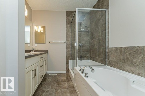 Dual vanity with undermount sinks, contemporary light fixtures, and a framed mirror - 3203 Carpenter Landing Sw, Edmonton, AB 