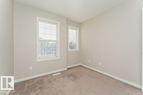 Neutral wall paint, textured ceiling, two windows with blinds, and carpeting - 3203 Carpenter Landing Sw, Edmonton, AB 