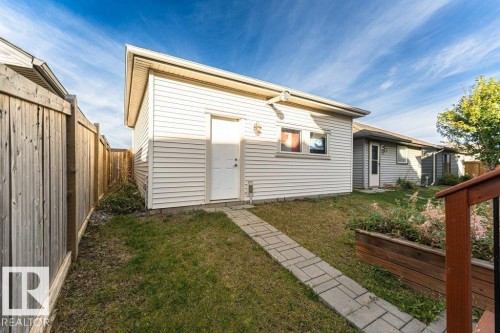 Detached outbuilding with white vinyl siding, a white entry door, and a single window - 3203 Carpenter Landing Sw, Edmonton, AB 
