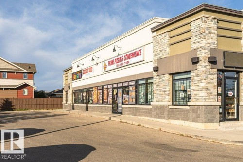 Commercial building featuring a stone facade and multiple storefront windows - 3203 Carpenter Landing Sw, Edmonton, AB 