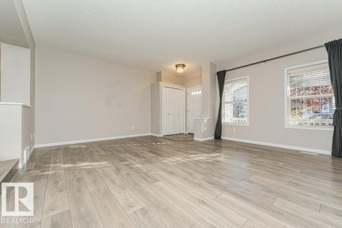 Spacious interior with neutral wall tones and wood-finish flooring - 3203 Carpenter Landing Sw, Edmonton, AB 