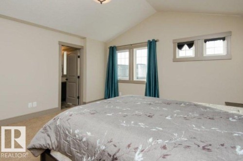 Vaulted ceiling, two distinct window sets, broad baseboards, and a paneled interior door - 7233 Armour Crescent Sw, Edmonton, AB 