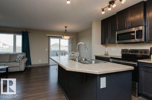 Kitchen island with integrated double basin sink and gooseneck faucet - 7233 Armour Crescent Sw, Edmonton, AB 