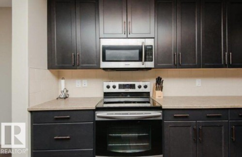 Dark-toned cabinetry featuring bronze-finish hardware - 7233 Armour Crescent Sw, Edmonton, AB 