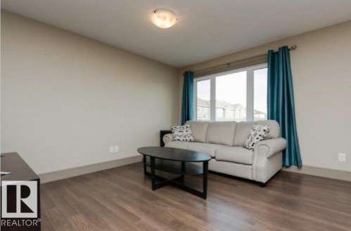 Recessed ceiling light fixture, wood-finish flooring, and a large window - 7233 Armour Crescent Sw, Edmonton, AB 