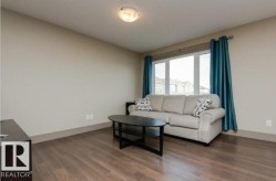 Recessed ceiling light fixture, wood-finish flooring, and a large window - 
