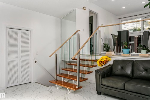 Floating staircase with wood treads and glass railings - 7204 92B Avenue Nw, Edmonton, AB 