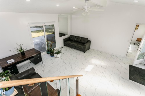 Vaulted ceiling with a ceiling fan, recessed lighting, white tile flooring, and sliding glass doors - 7204 92B Avenue Nw, Edmonton, AB 